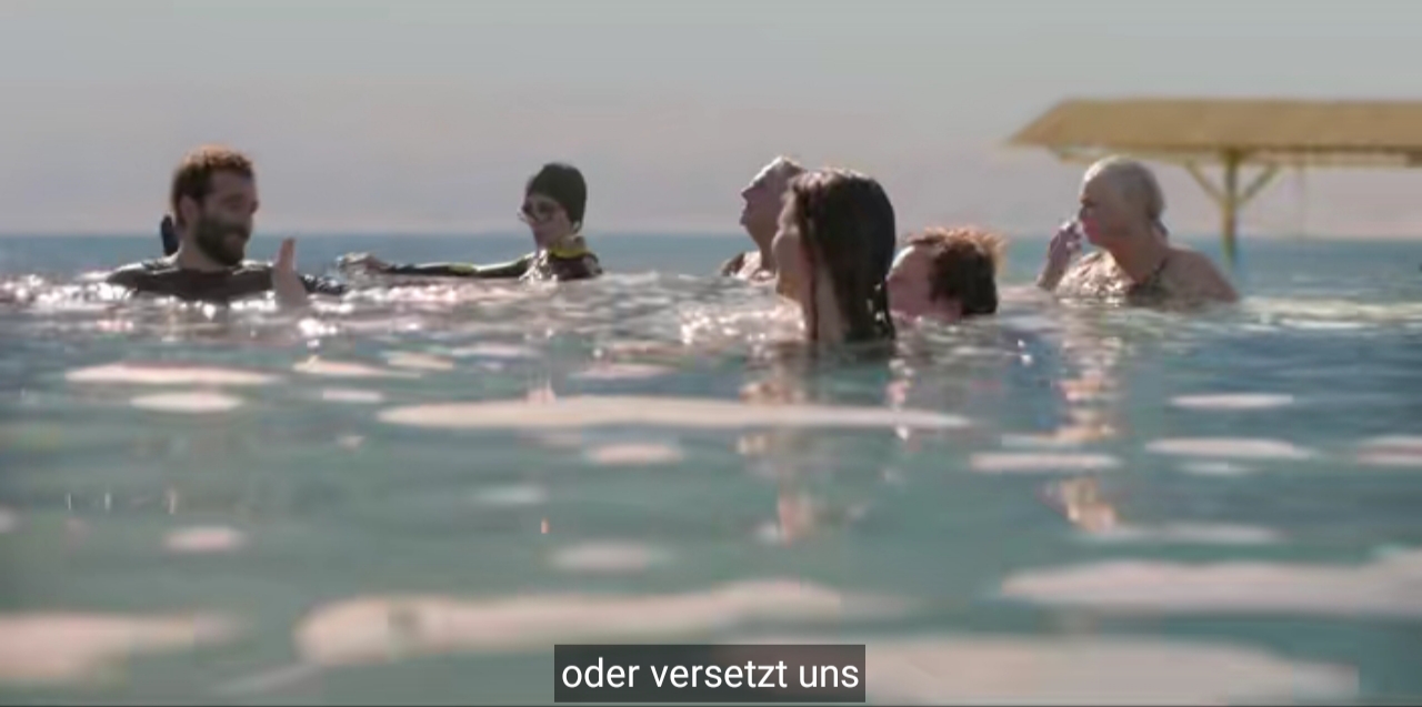 Der bärtige ist mit fünf anderen Menschen verschieden Alters im Wasser und fährt fort: oder versetzt uns.