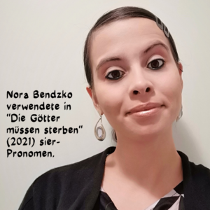 Porträtfoto von Nora mit langen nach hintengebundenen Haaren und einer scharzen Strickjacke und baumelndem Ohrring.
Text: Nora Bendzko verwendete in 