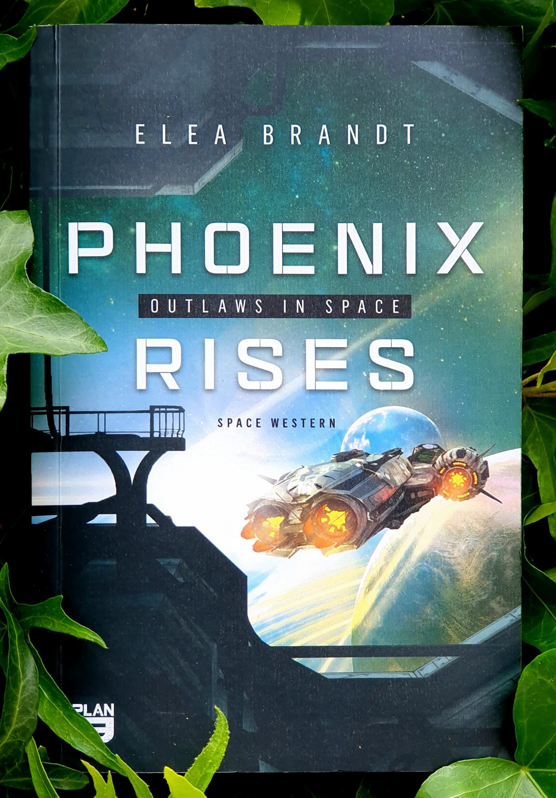 Foto des Buchcovers von Outlaws in Space - Phoenix rises - Space Western von Elea Brandt im Plan 9 Verlag umrankt von Efeu. Alle Info mit weißen Buchstaben. Im Hintergrund startet eine kleines Raumschiff aus dem Hangar in Richtung Weltall, zwei Planeten sind ganz nah, dahinter Sternenhimmel.