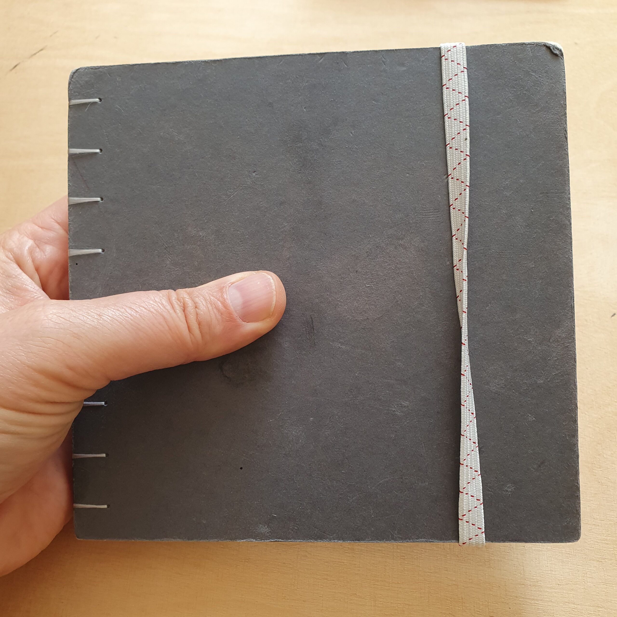 Foto vom dunkelgrauen quadratischen Skizzenbuch