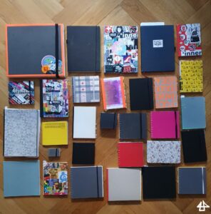 30 Bücher auf dem Parketboden, DinA5, DinA4, und viele quadratische, das Grösste mit 30cm Länge das Kleinste mit circa 4 cm.