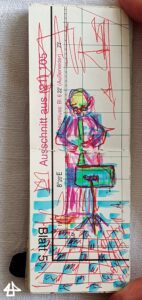 Foto eines schmalen Skizzenbuches was in der Länge zwischen Daumen und Zeigefinger passt. Hochkant ein Mensch mit schmalem Blasinstrument und Notenständer, der Fussboden hell und dunkel wie ein Schachbrett gefliest, skizzenhaft: blau, gelb, magenta und rot.